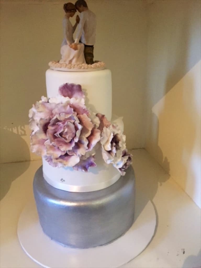 Three-tier wedding cake with silver tier and purple peony sugarwork